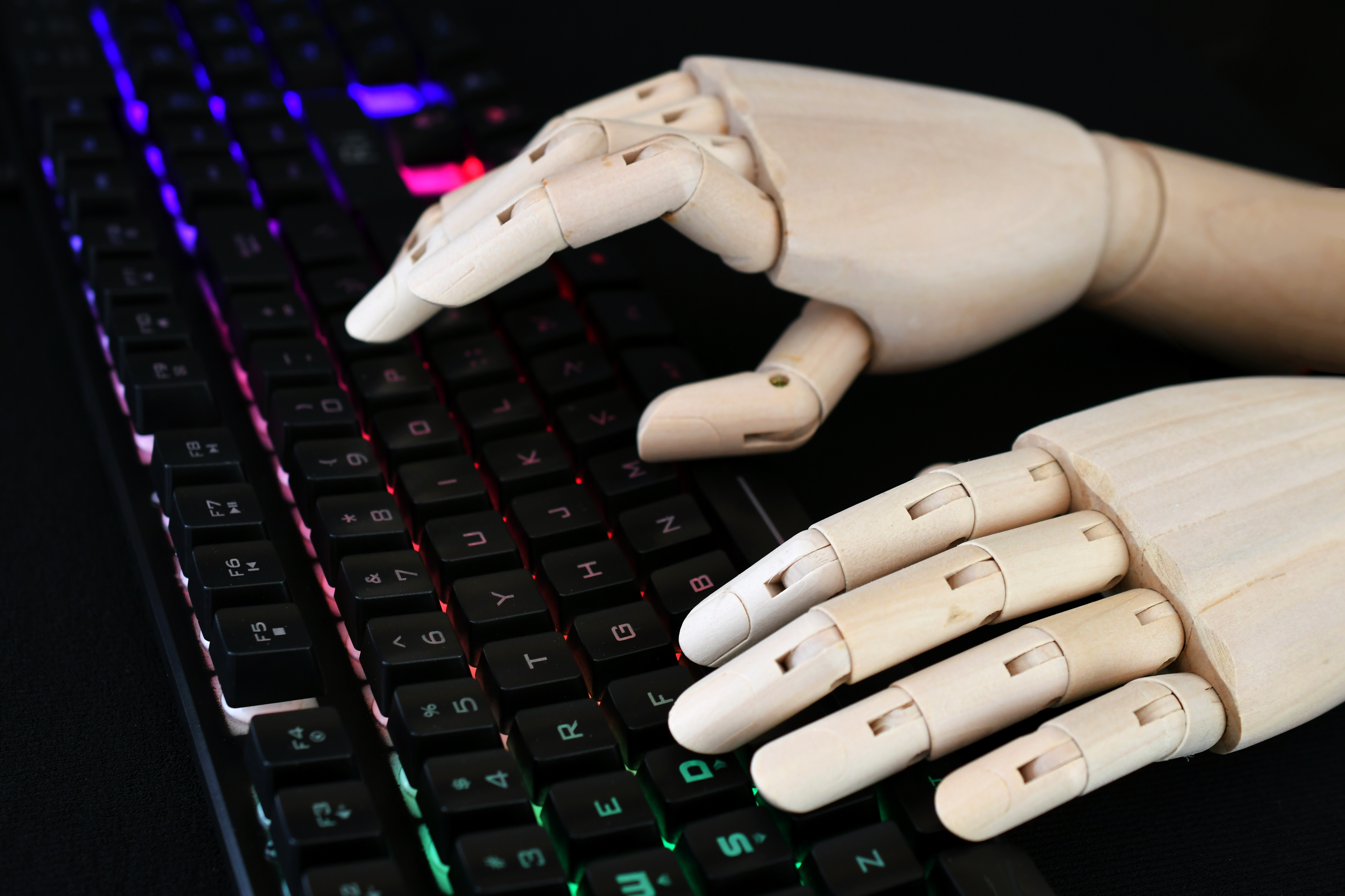 ai artificial intelligence concept robot hands typing on lit keyboard