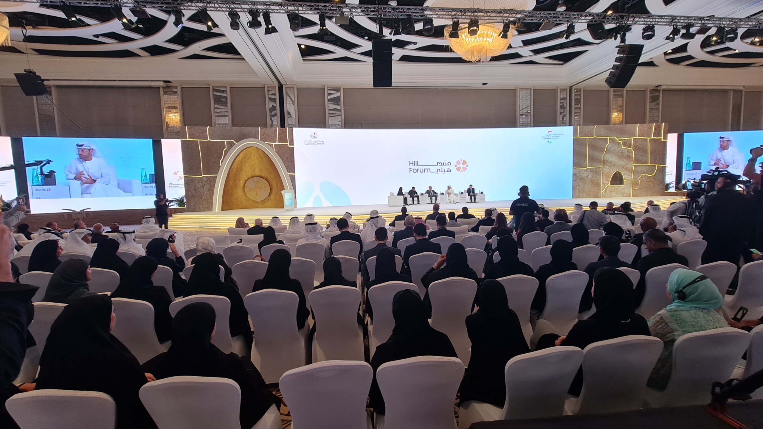 20250909_100838 People, Person, Indoors, Architecture, Building, Classroom, Room, School, Crowd, Adult, Female, Woman, Hall, Audience, Lecture, Lecture Hall, Face, Head, Chair, Furniture, Computer Hardware, Electronics, Hardware, Monitor, Screen, Tareq Al-Suwaidan, Simon Geschke