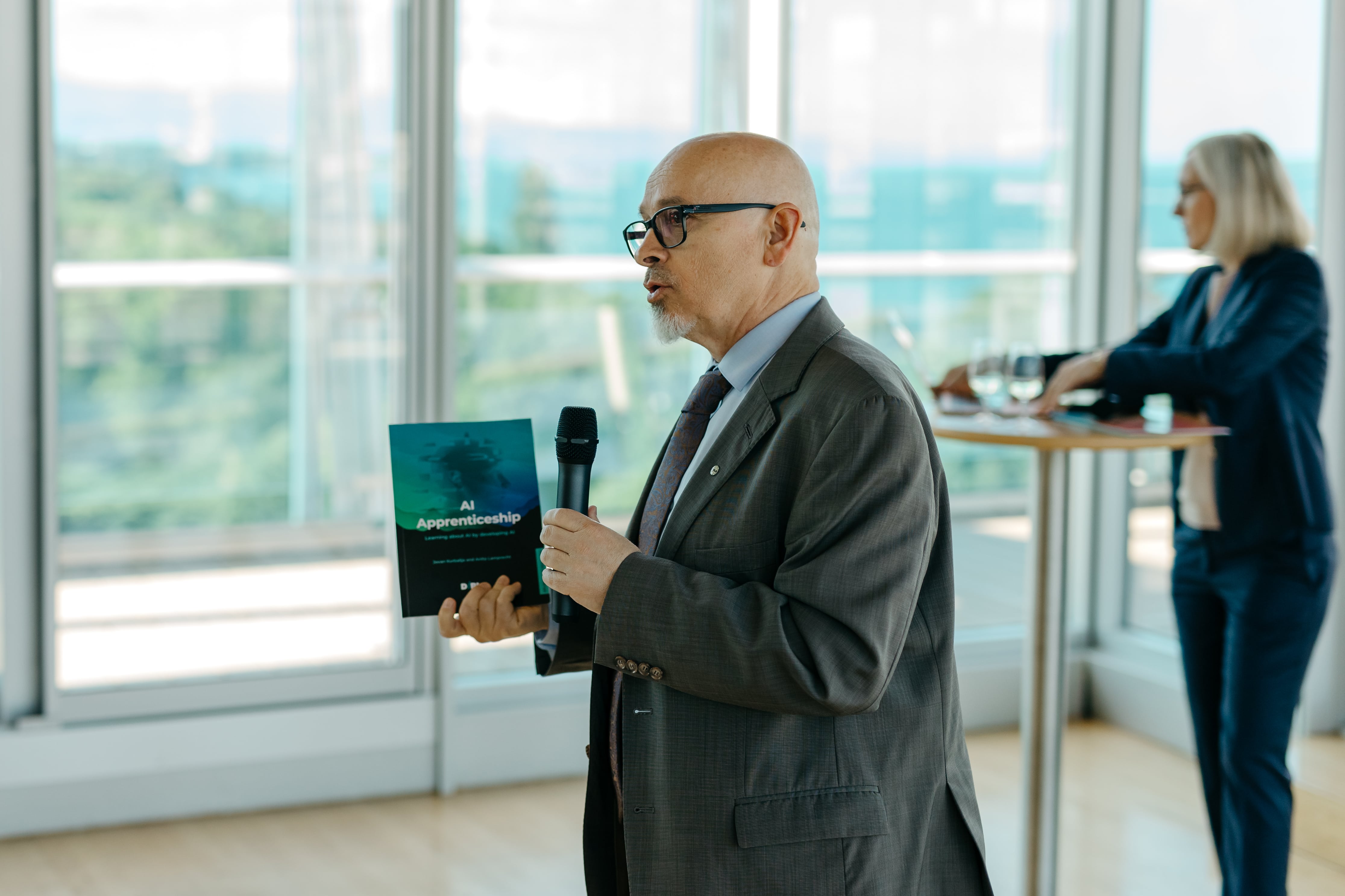 LAZA1967-min Adult, Female, Person, Woman, Male, Man, Electrical Device, Microphone, Accessories, Formal Wear, Tie, Executive, Head, Furniture, Table, Desk