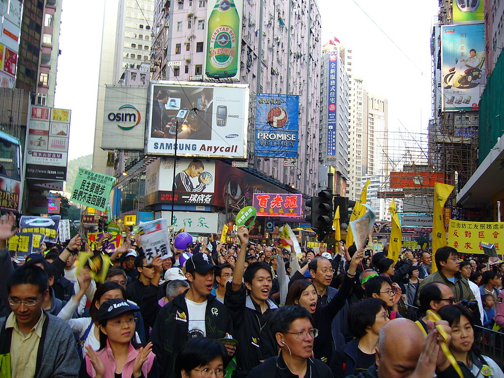 The impact of NGOs on international policymaking 1 The image shows a photograph of a crowd of protesters in a city environment