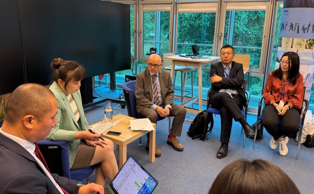 Adult, Female, Person, Woman, Conversation, Male, Man, Interview, Accessories, Bag, Handbag, Electronics, Mobile Phone, Phone, Face, Head, Clothing, Footwear, Shoe, Computer, Laptop, Pc, Formal Wear, Suit, Tie, Chair, Furniture, Wristwatch, Coat, Juanma Bajo Ulloa, Amber Holland