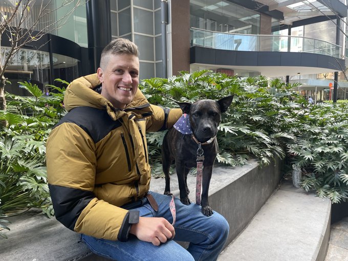  Clothing, Coat, Pants, Plant, Potted Plant, Jacket, Face, Head, Person, Photography, Portrait, Adult, Male, Man, Sitting, Architecture, Building, Outdoors, Shelter, Vegetation, Tree, Nature, Herbal, Herbs, Animal, Canine, Mammal, Pet, Jeans