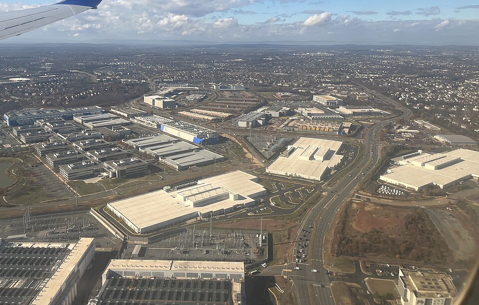 The image shows an aerial photograph of large warehouse buildings.